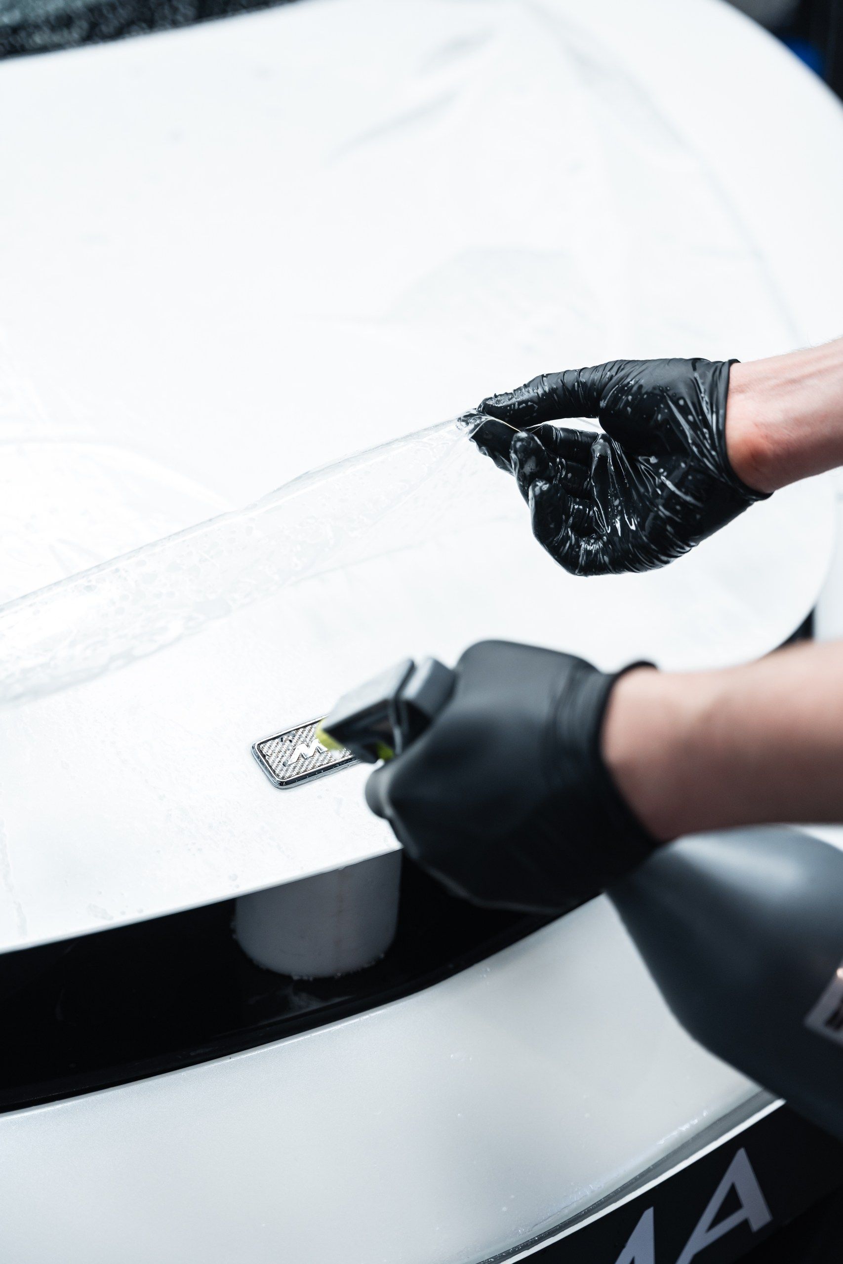 Pose d'un film PPF sur le capot d'un véhicule.