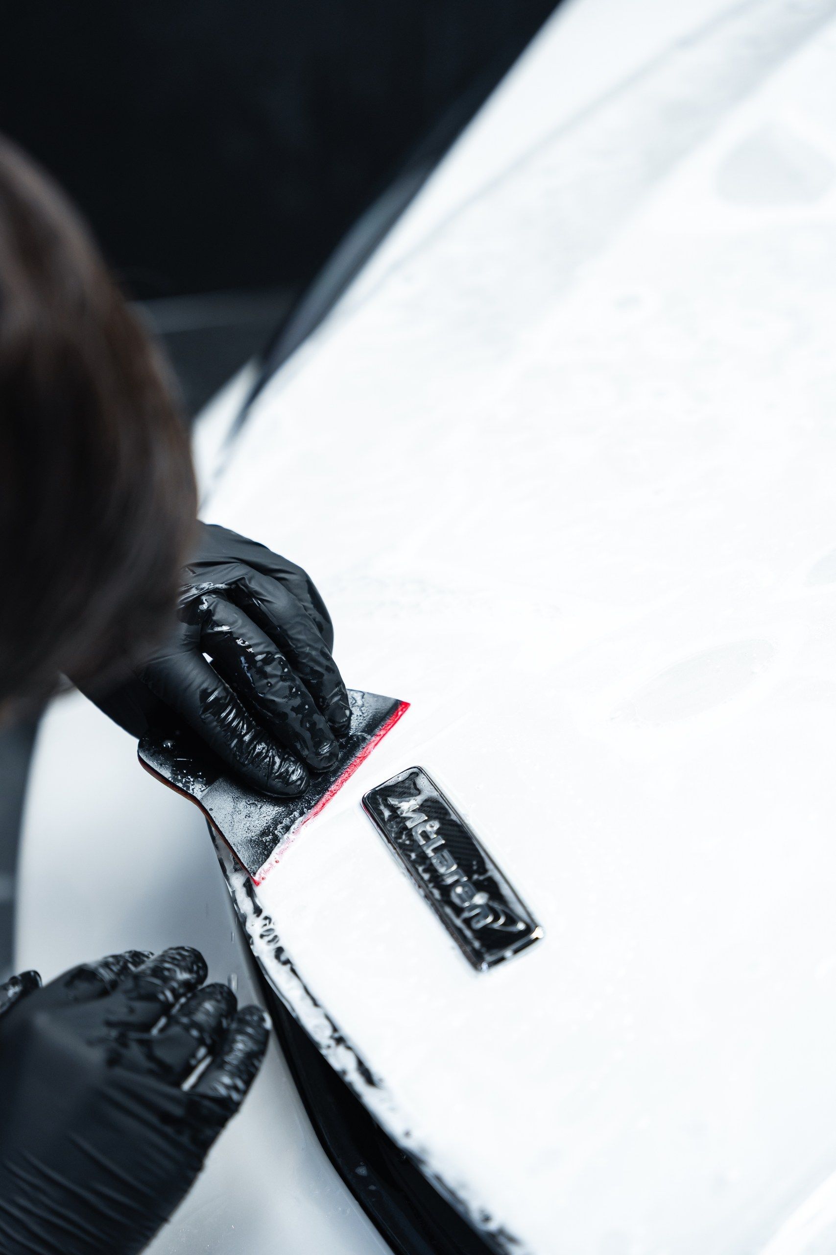 Pose d'un film PPF sur le capot d'un véhicule.