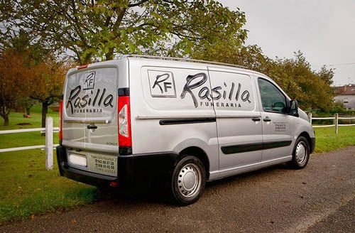 Una camioneta blanca con la palabra rastilla en el costado está estacionada al costado de la carretera.
