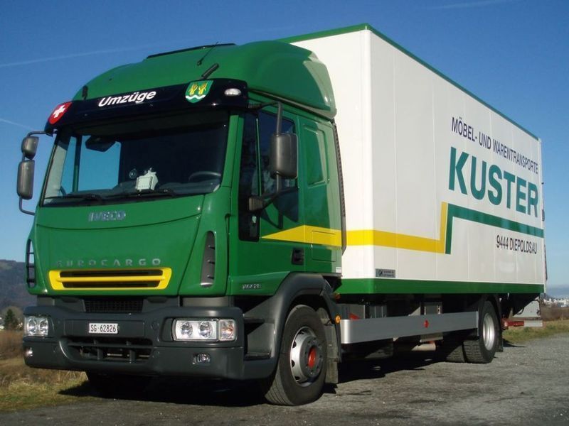 Grün-weißer Kuster-Transportwagen auf einer Straße, Schweiz.