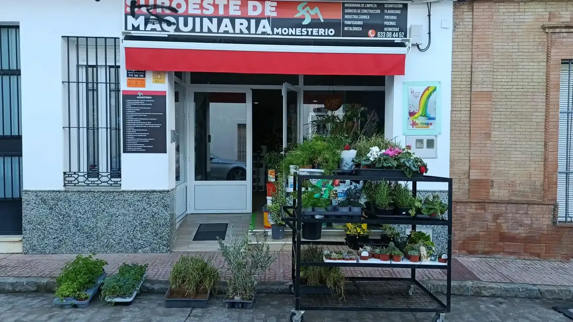 Una tienda con toldo rojo. Hay plantas expuestas en la entrada. El letrero dice 