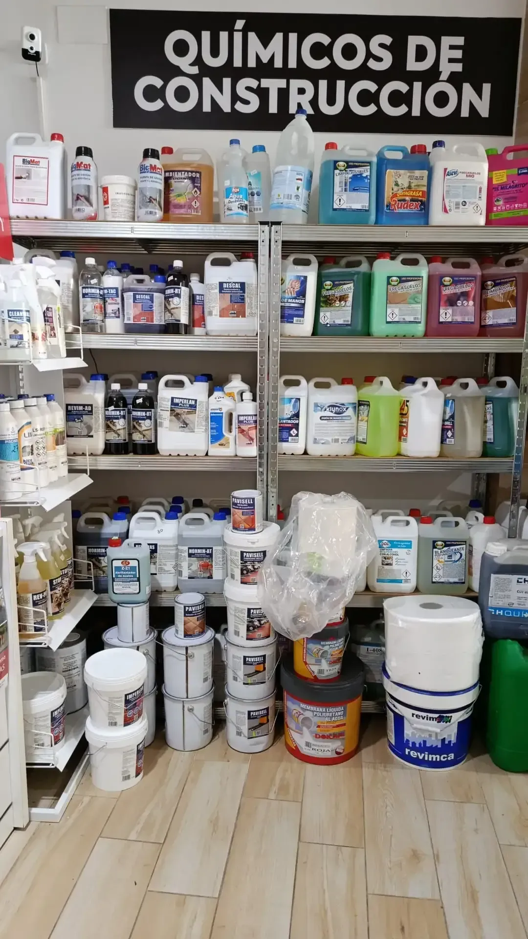Estantes llenos de productos químicos para la construcción en una tienda. El texto dice 