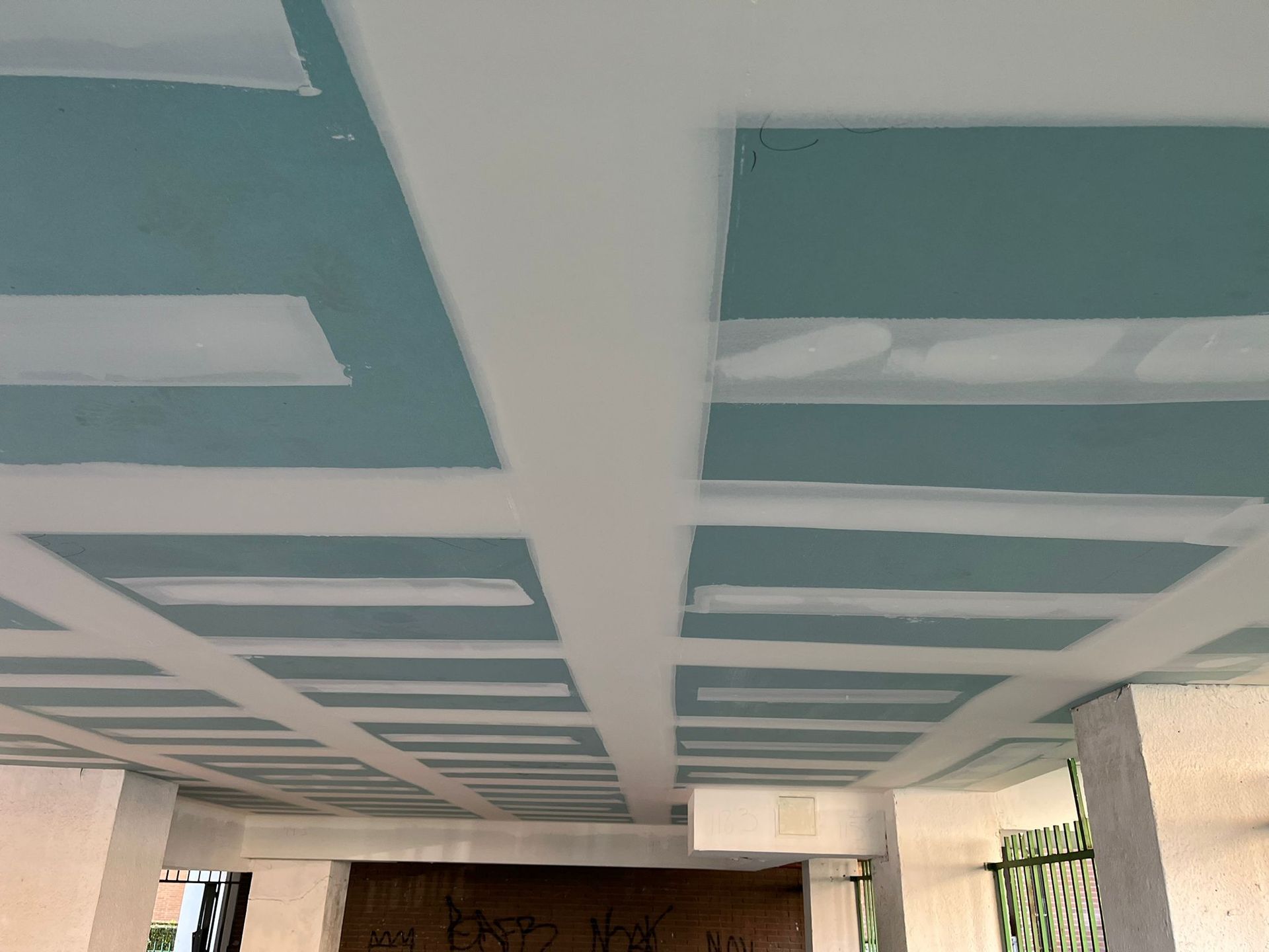 Tres paneles de espuma acústica: acanalado negro, piramidal naranja y enrollado en color canela sobre fondo gris.