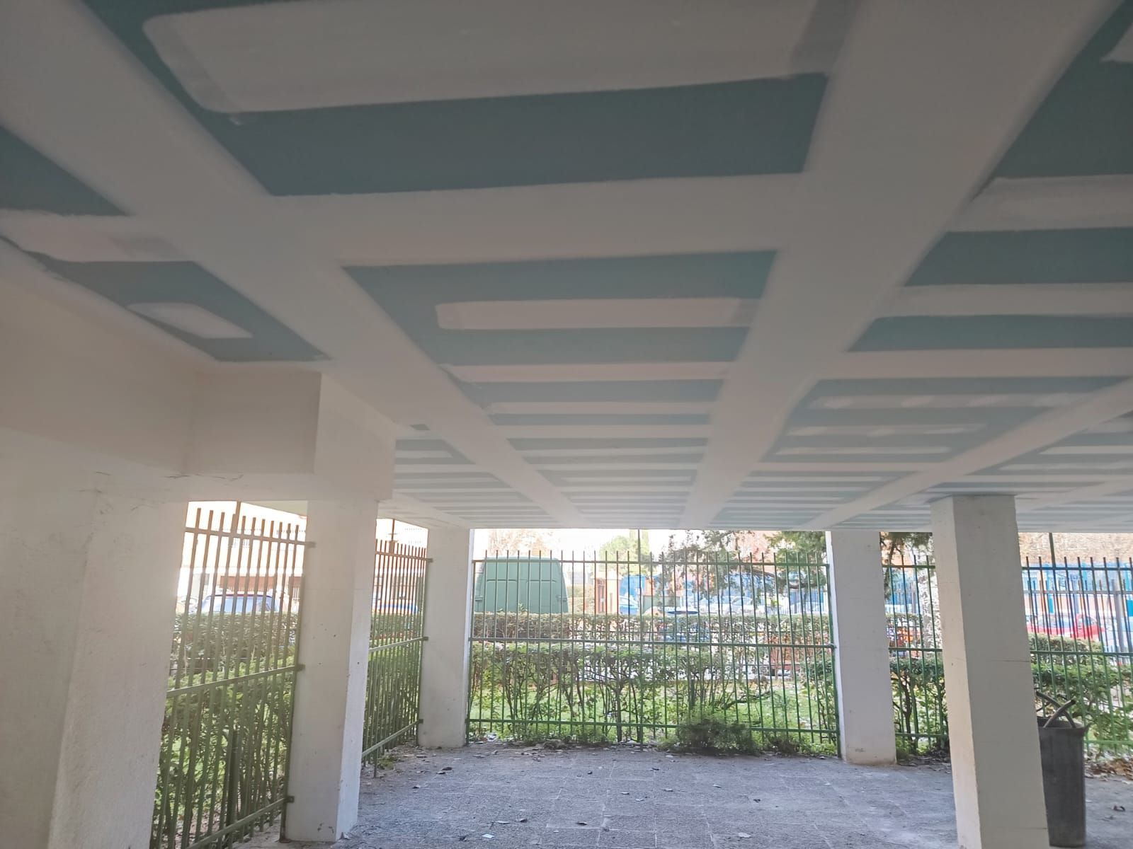 Láminas de yeso se apoyan contra una pared en una habitación en construcción; blancas, verdes y grises.