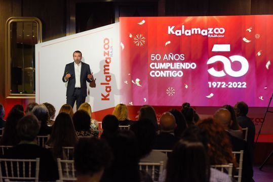 Un hombre está dando una presentación frente a una multitud de personas.