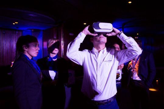 Un hombre lleva un casco de realidad virtual en una habitación oscura.