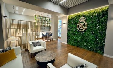 Una sala de estar con una pared verde y un logotipo en ella.