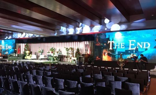 Un auditorio vacío con una pantalla grande que dice el final