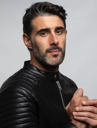 Un hombre con barba lleva una chaqueta de cuero negra.