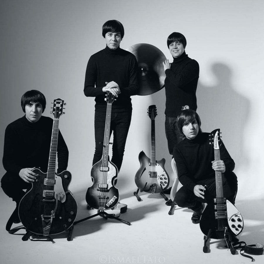 Una foto en blanco y negro de los Beatles con sus guitarras.
