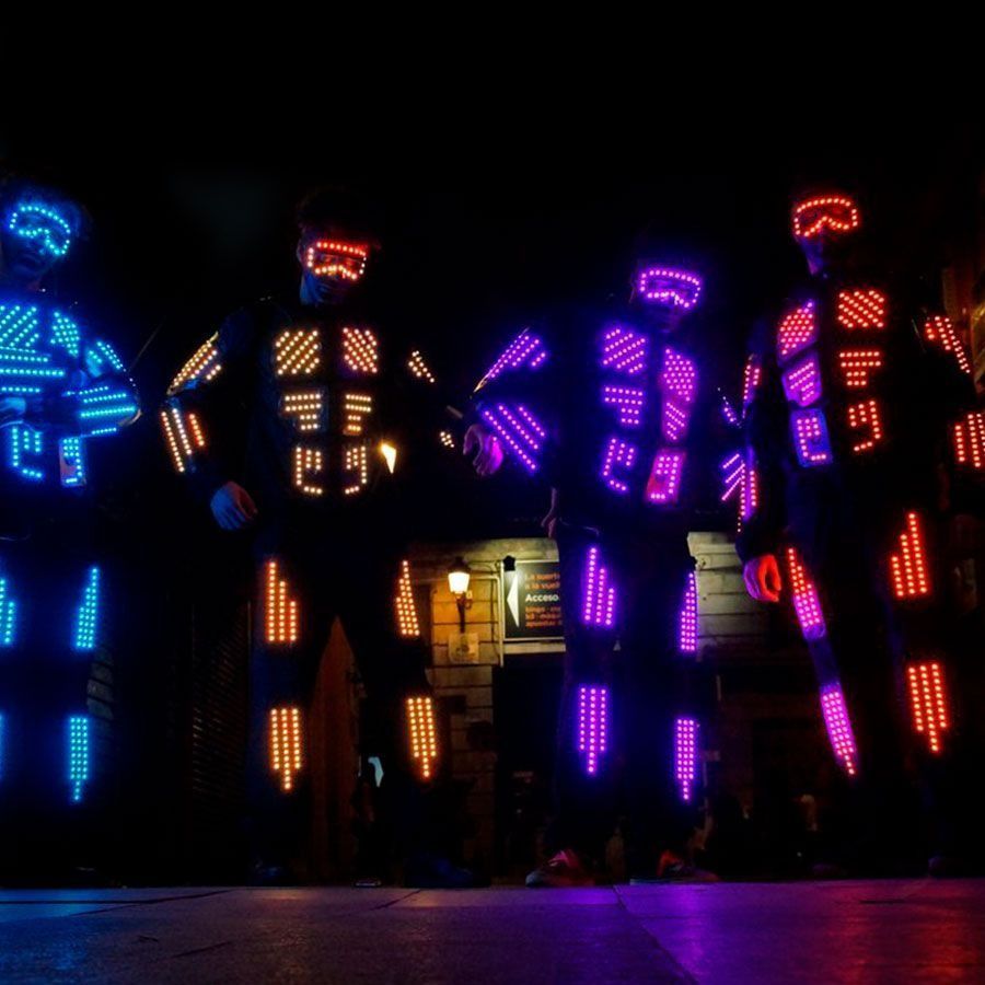 Un grupo de personas están vestidas con disfraces que brillan en la oscuridad.