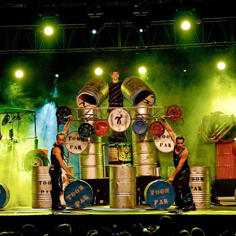 Un grupo de hombres están parados encima de barriles que dicen