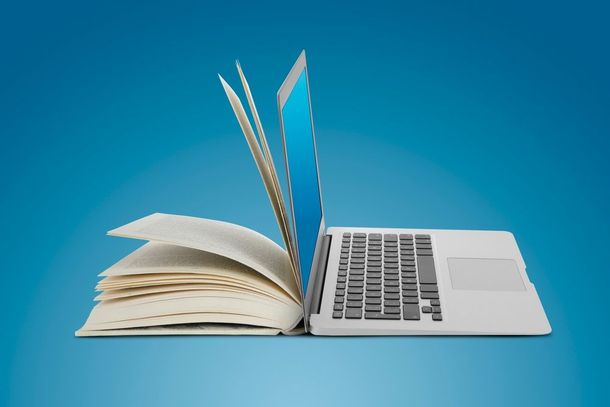 Una computadora portátil está encima de un libro abierto