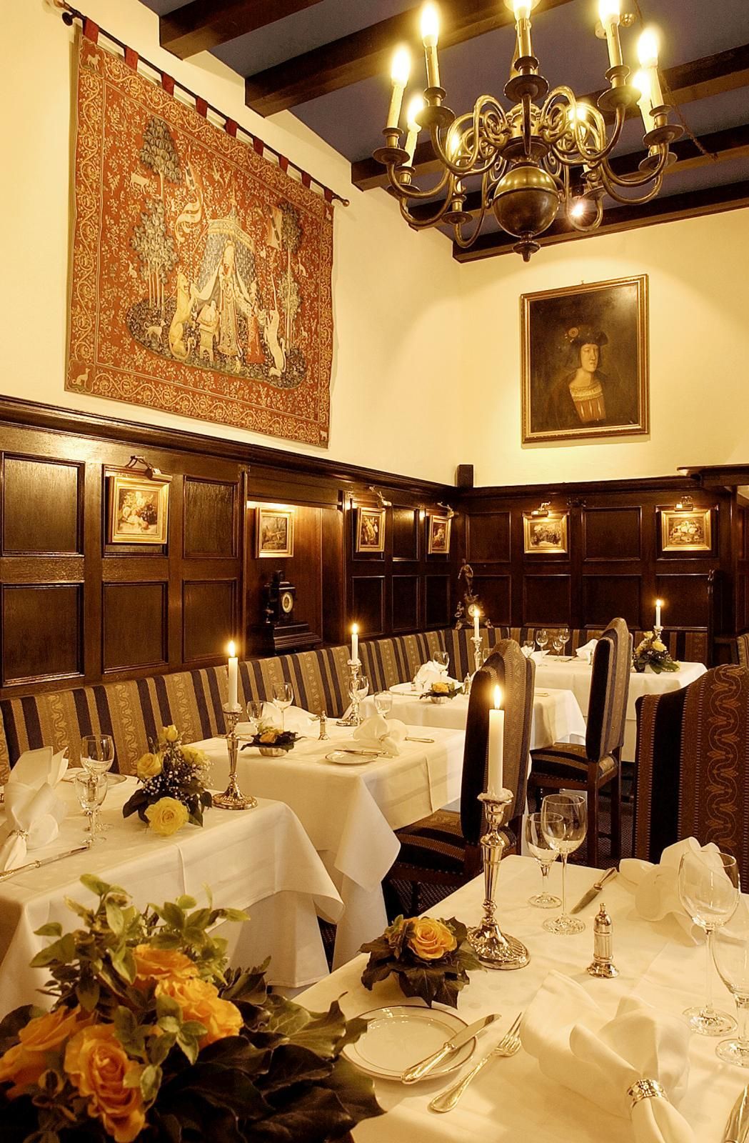 A dining room with tables and chairs and candles