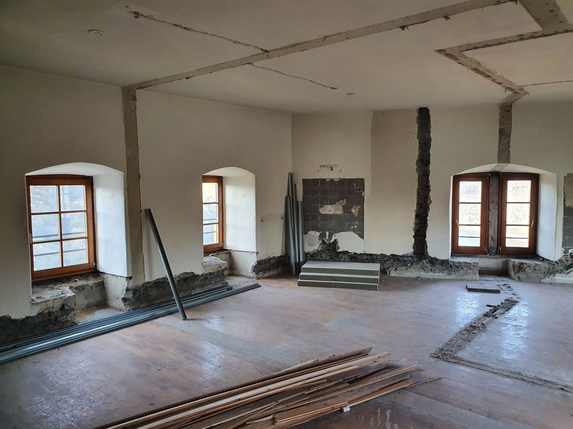 Ein Raum mit vielen Fenstern und einem Holzboden
