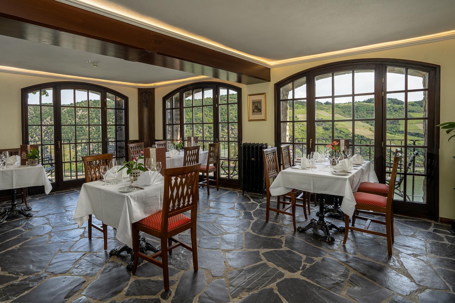 Ein Restaurant mit Tischen und Stühlen und vielen Fenstern.