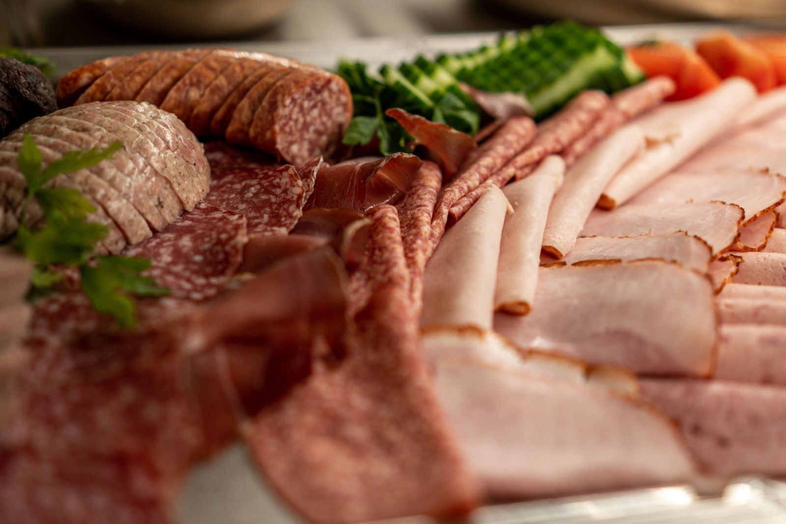 Eine Nahaufnahme eines Tellers mit Fleisch und Gemüse auf einem Tisch. Frühstücksbuffet