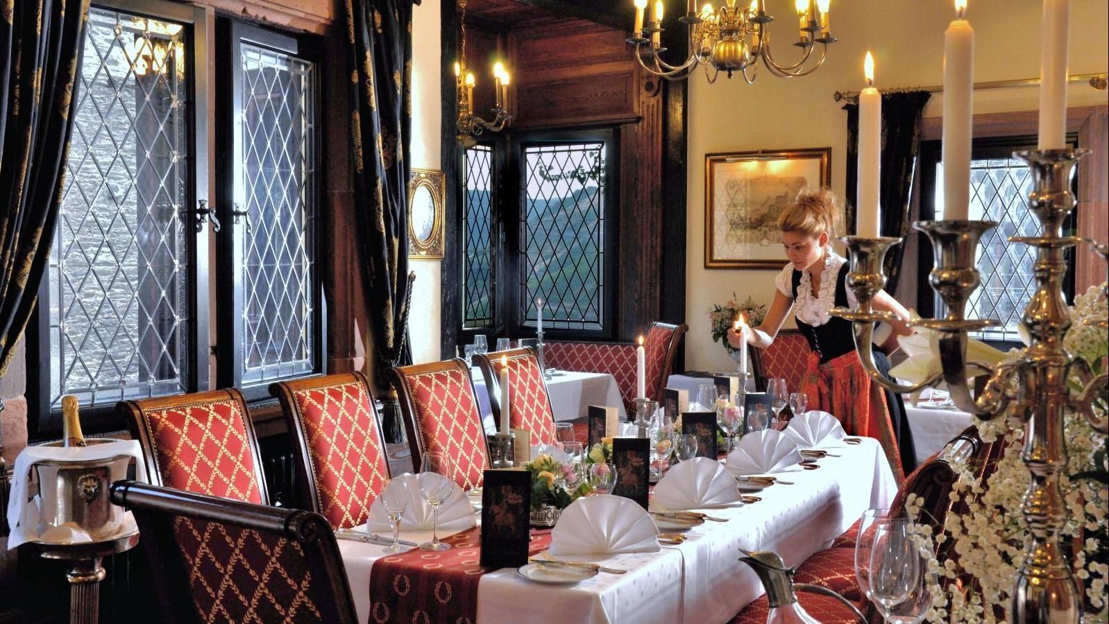 Eine Frau steht an einem langen Tisch in unserem Restaurant im Raum Ritterstube