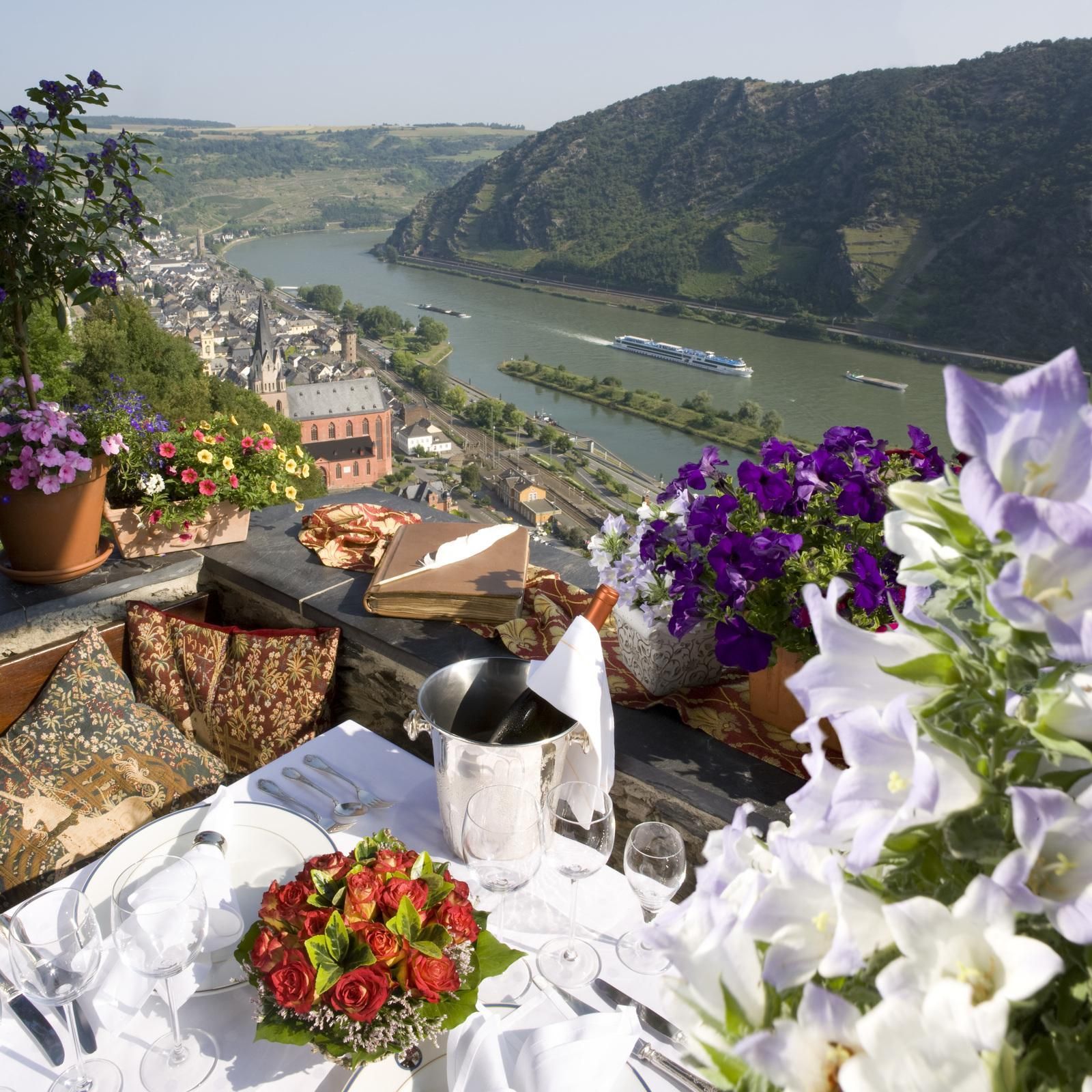 A table with flowers and a view of a river