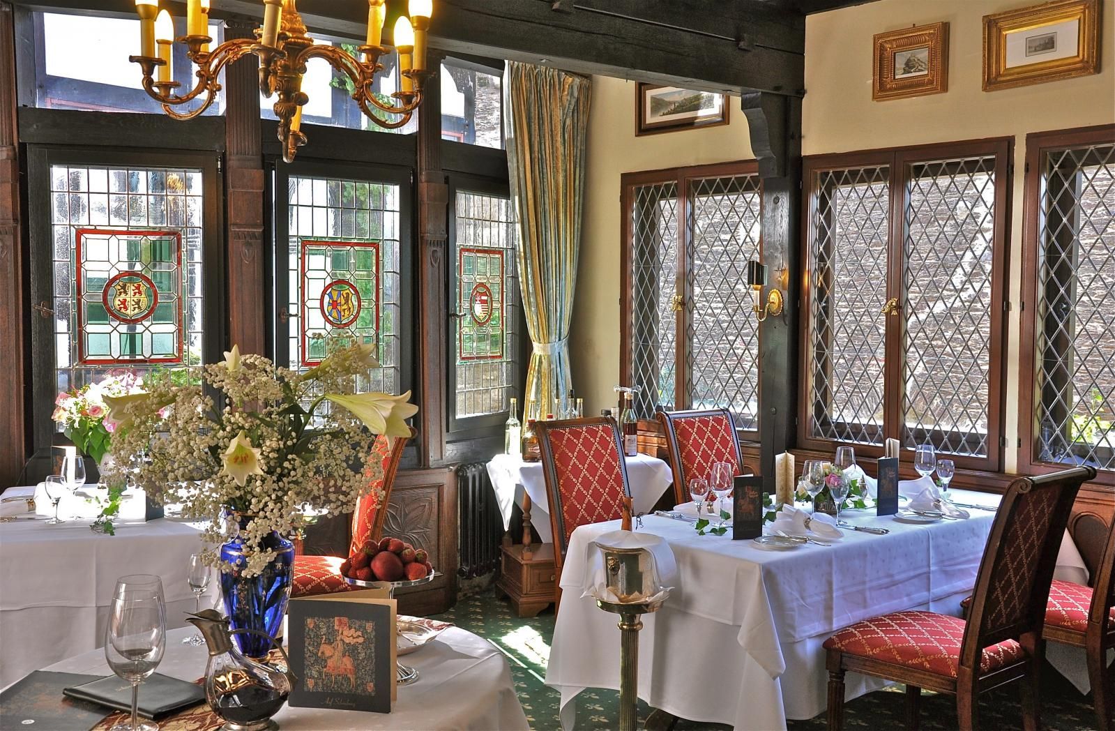 A dining room with tables and chairs and a chandelier