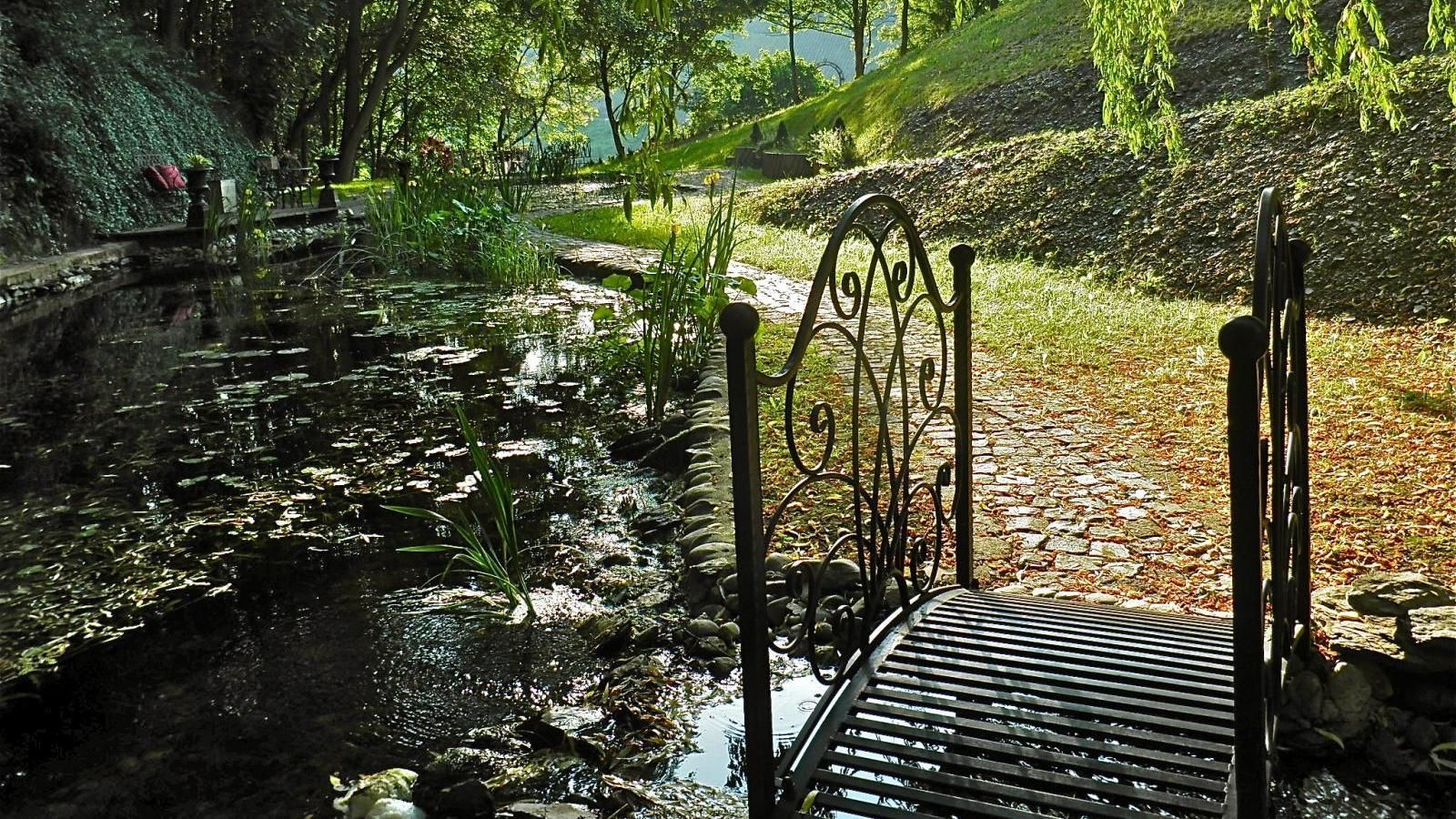 Eine kleine Brücke über einen Teich im Garten.