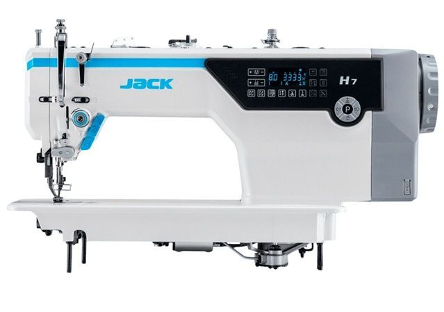Máquina de coser azul y blanca sobre una mesa de trabajo en un taller o estudio.