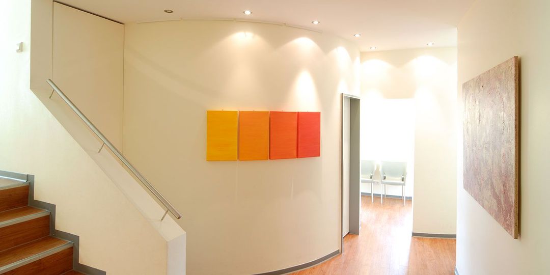 Ein Flur mit Treppe und einem Gemälde an der Wand