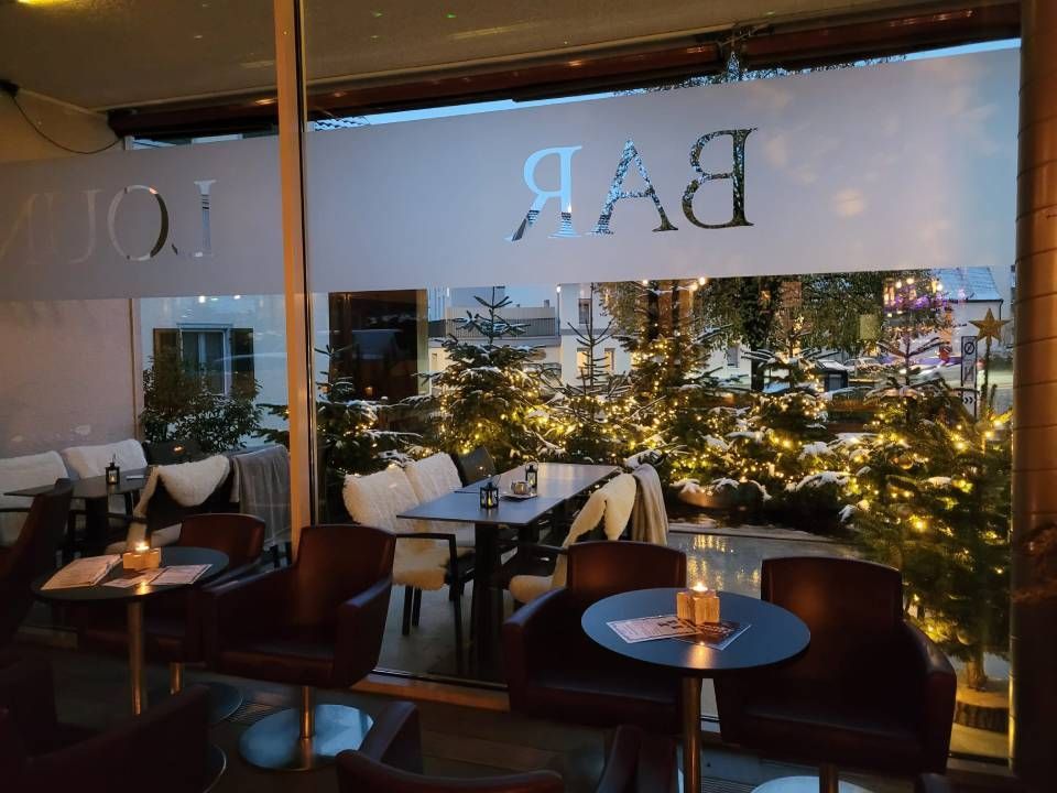 Tische und Stühle mit einem Weihnachtsbaum im Hintergrund. Foto der Viva Bar & Lounge