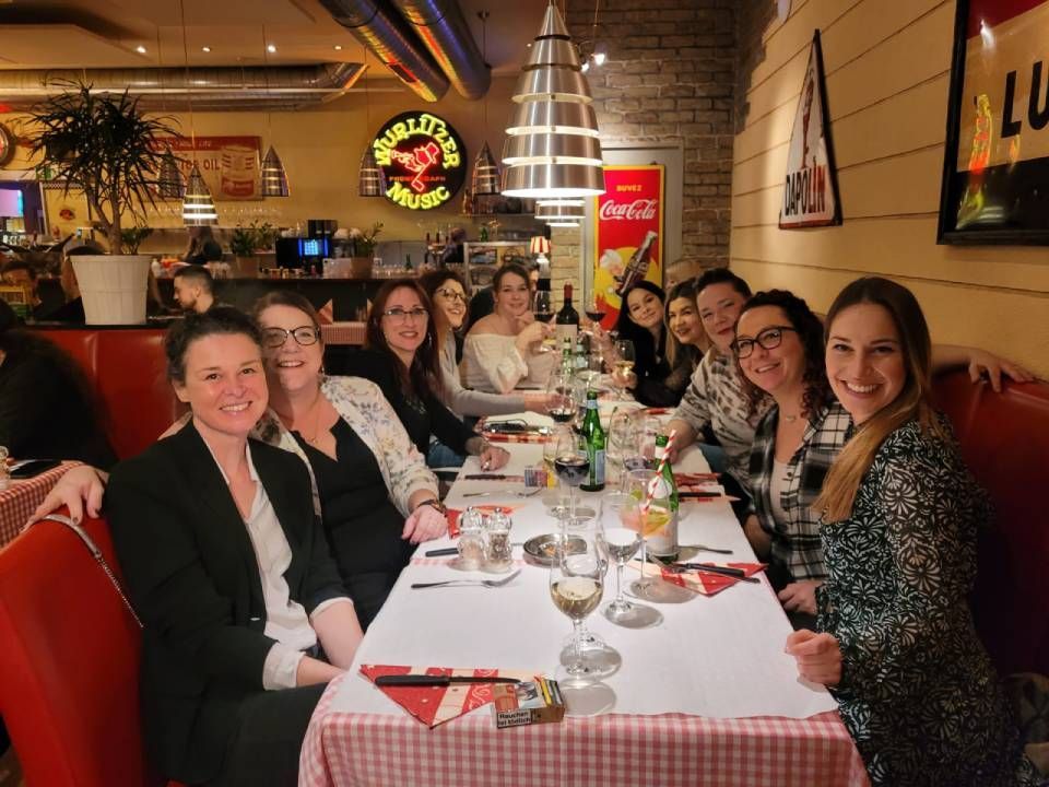 Eine Gruppe lächelnder Menschen an einem Tisch in der Viva Bar & Lounge