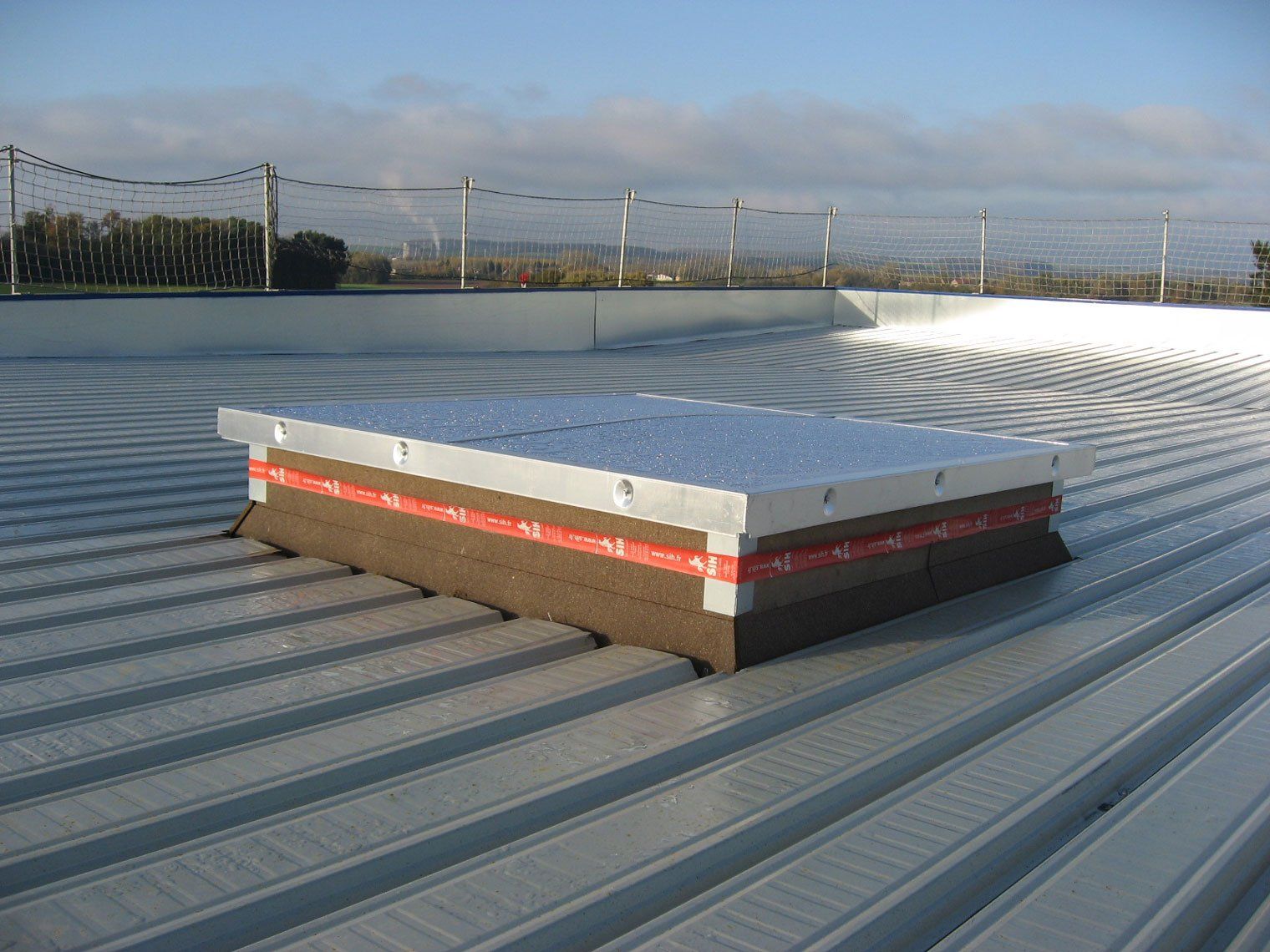 Étanchéité en cours d'installation sur toiture de bâtiment commercial