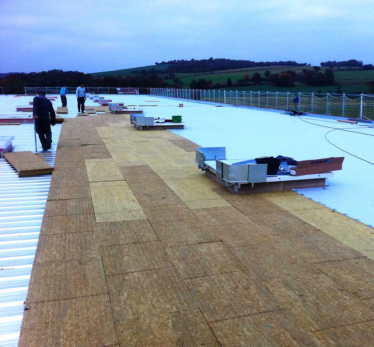 Une équipe recouvrant l'isolation d'une toiture