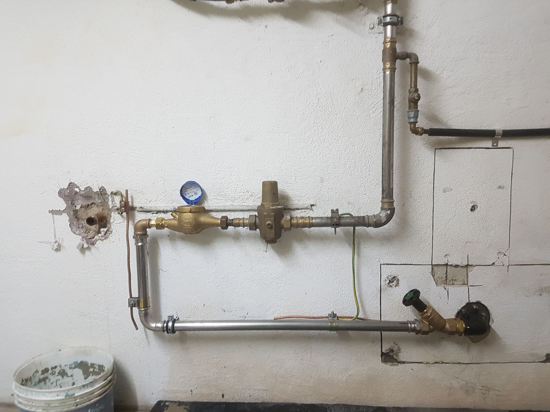 Ein Klempner arbeitet mit einem Schraubenschlüssel an einem Rohr. Sollberger & Co. AG