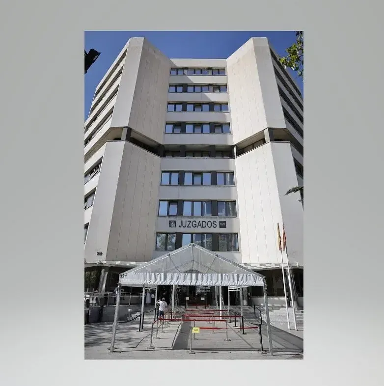 Una imagen de un edificio con una tienda de campaña delante de él.