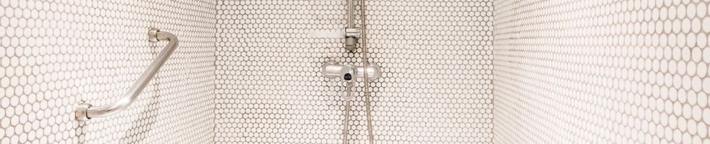 Una cabina de ducha con pasamanos y cabezal de ducha.