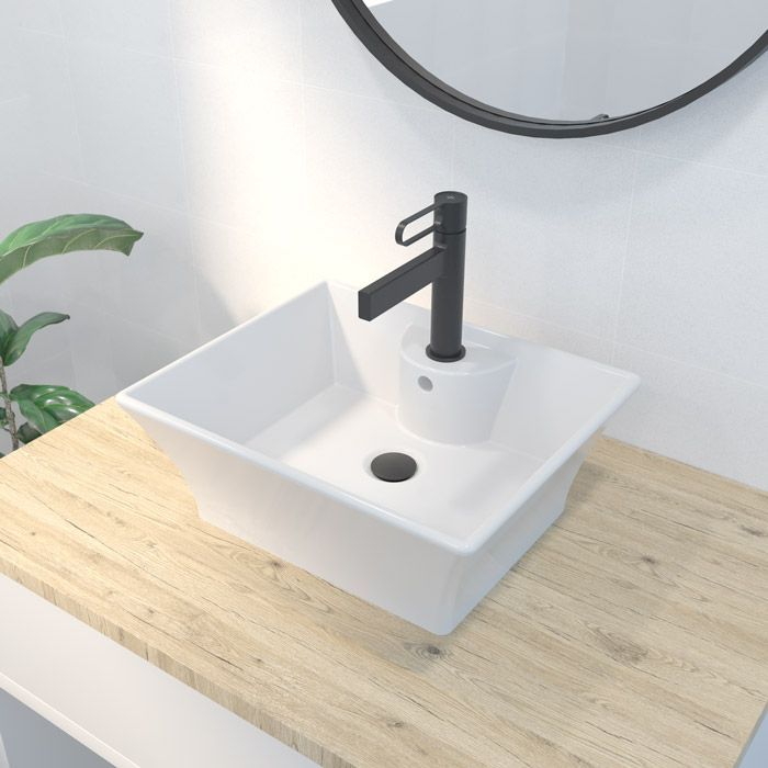 Un lavabo de baño con un grifo negro sobre una encimera de madera.