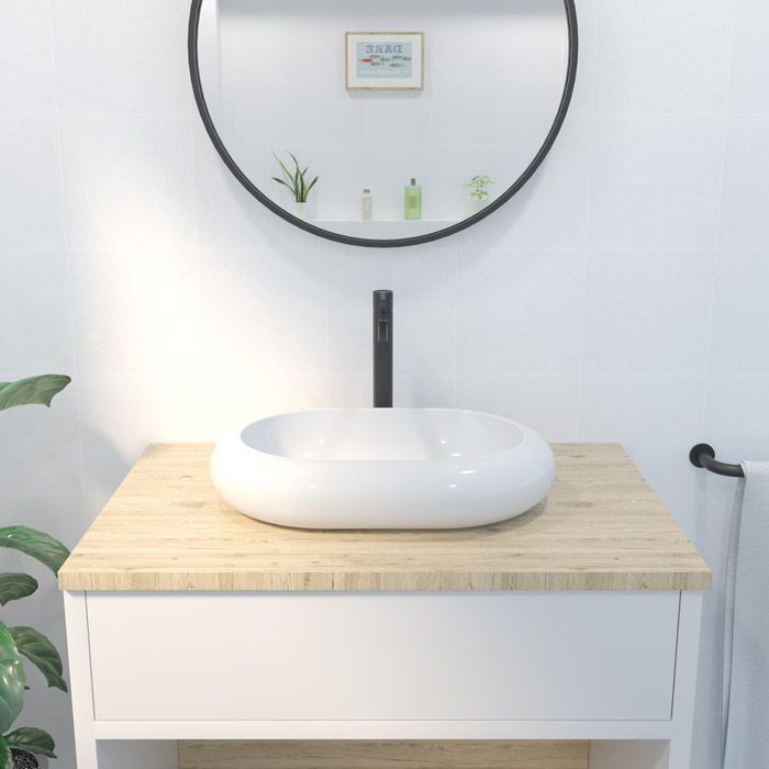 Un lavabo de baño con un espejo redondo encima.