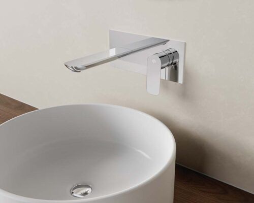 Un lavabo de baño con un grifo montado en la pared al lado.