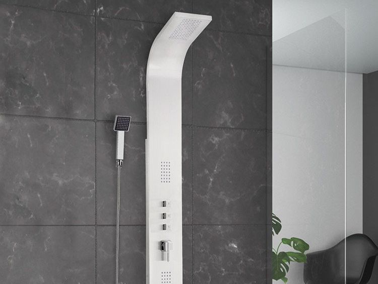 Un cabezal de ducha blanco está colgado en una pared negra en un baño.