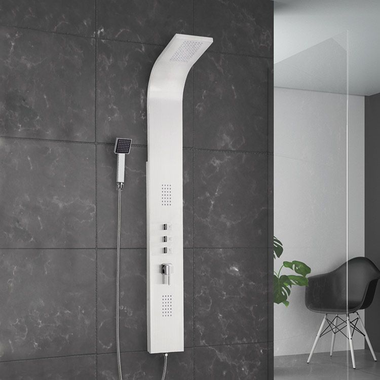 Un cabezal de ducha blanco está montado en una pared de azulejos negros.