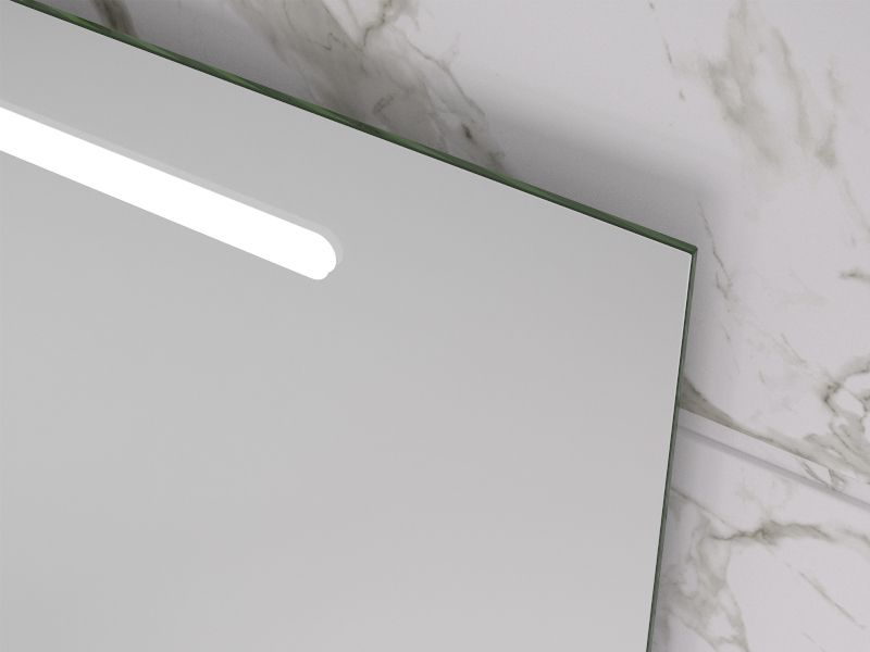 Un espejo de baño con luz está sobre una encimera de mármol.