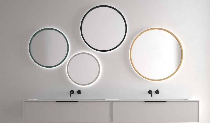 Un baño con dos lavabos y tres espejos en la pared.