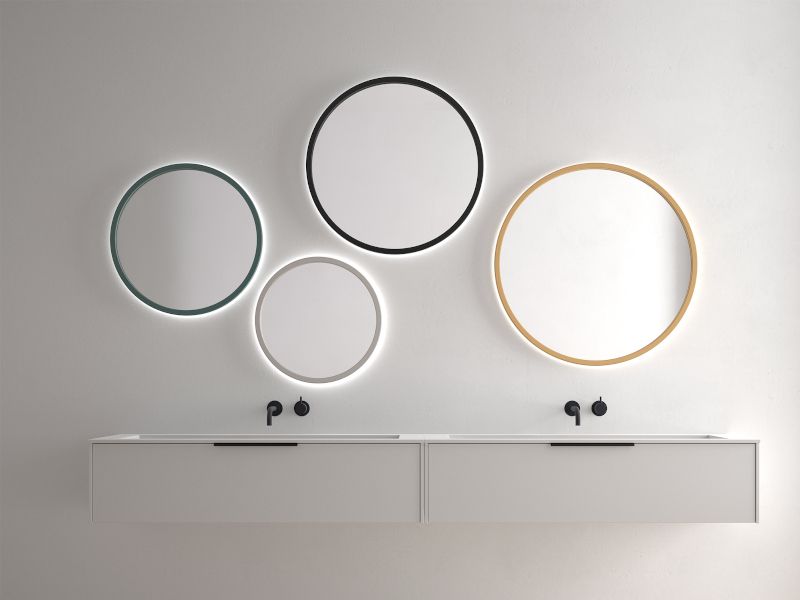 Un baño con dos lavabos y tres espejos en la pared.