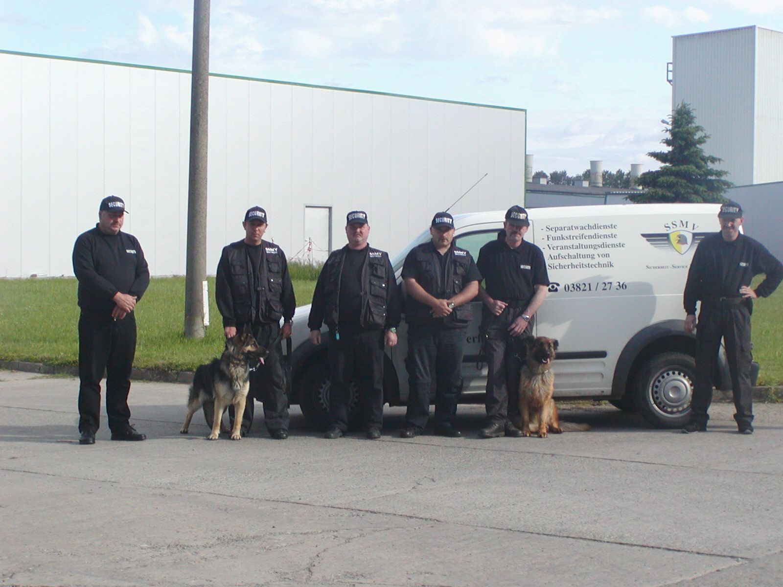Eine Gruppe von Männern steht vor einem weißen Lieferwagen