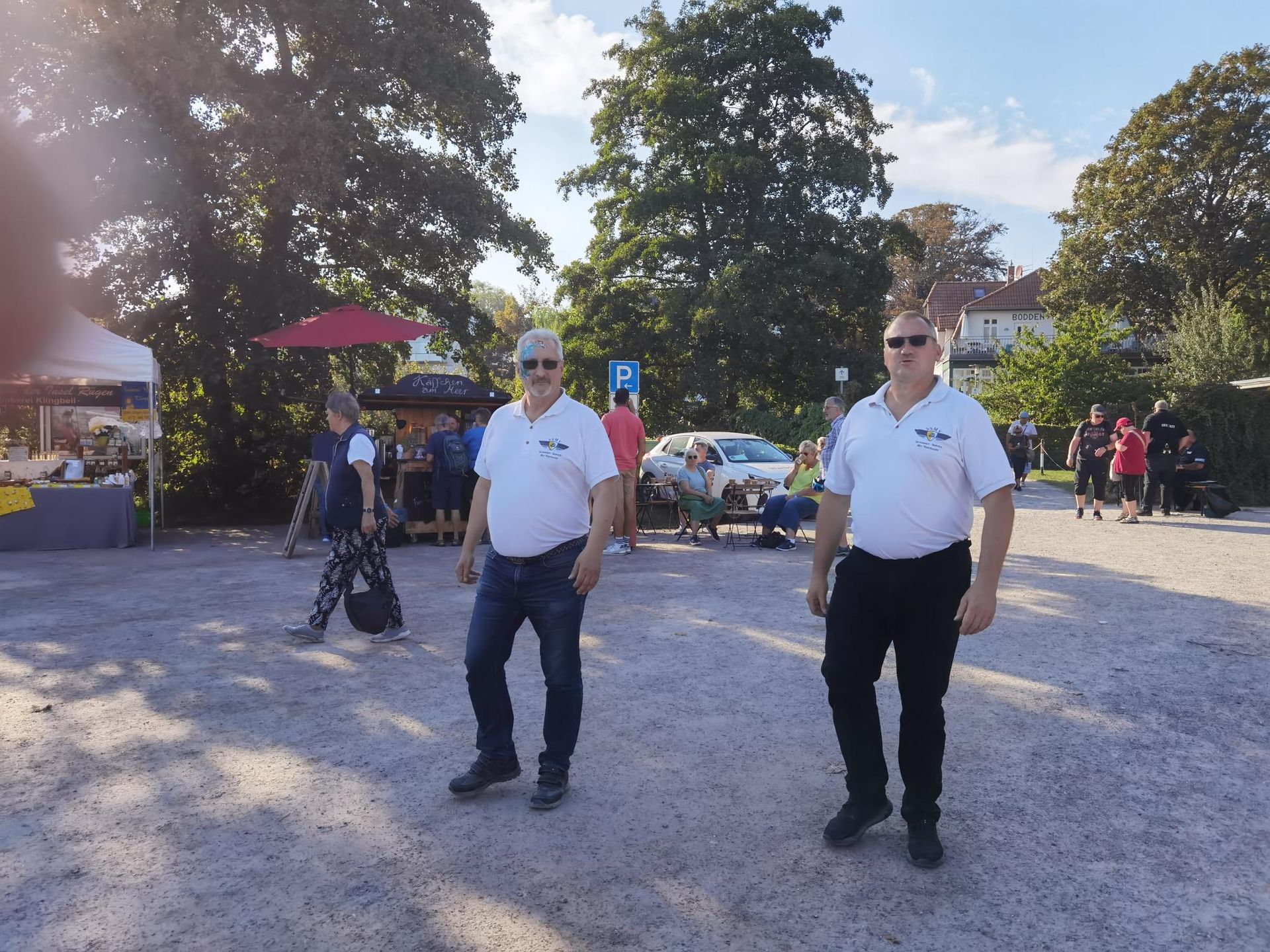 Zwei Männer stehen auf einem Parkplatz mit einem Schild mit der Aufschrift „P“ darauf