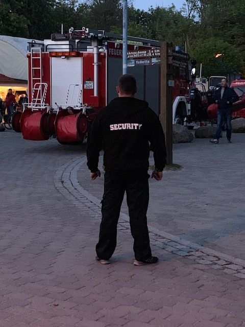 Ein Mann in einer Sicherheitsweste steht vor einem Feuerwehrauto