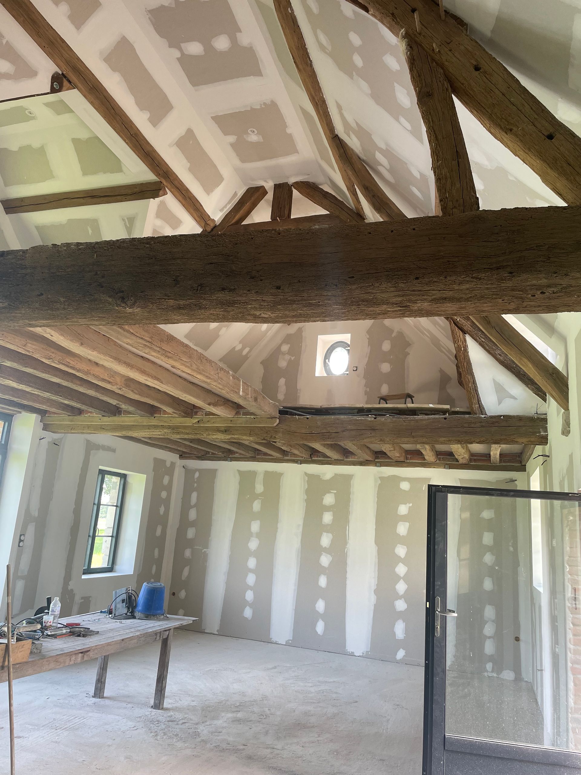 Plaques de plâtre posées avec poutres apparentes