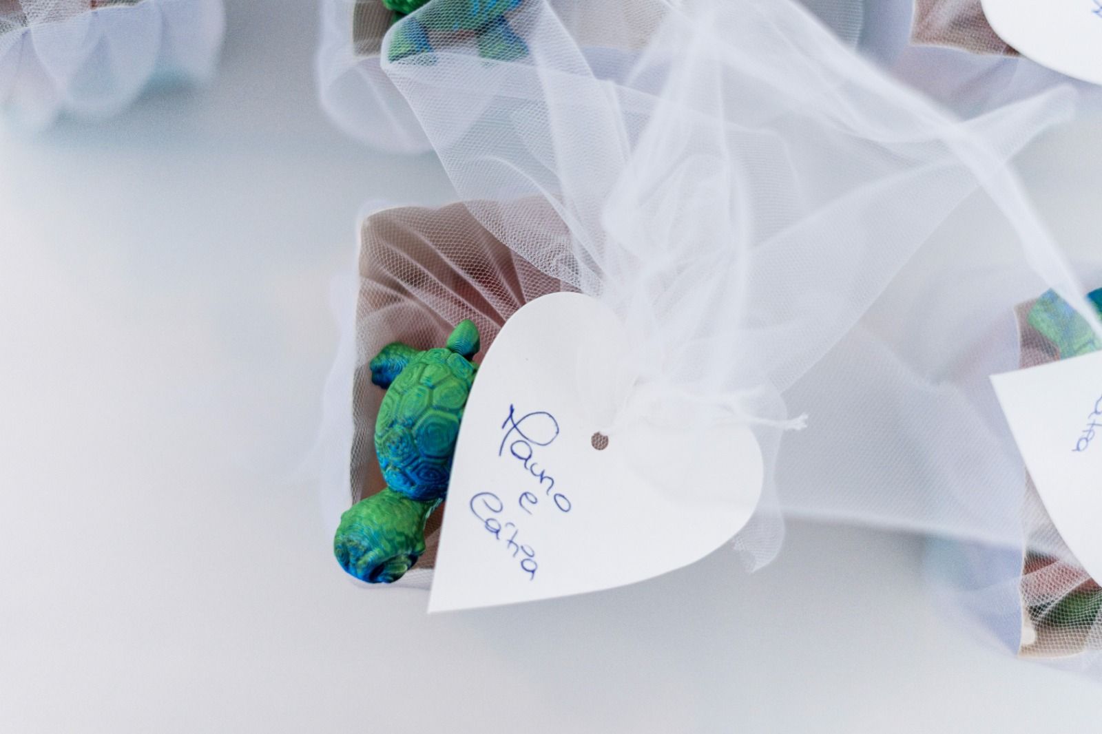 Etiqueta en forma de corazón con la inscripción manuscrita  atada a un regalo envuelto con una tortuga marina azul.