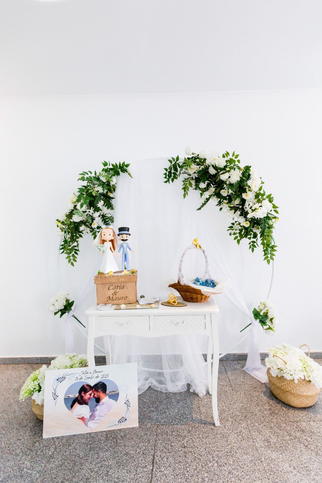 Mesa de recepción de boda con arco floral, foto de la pareja y decoración.