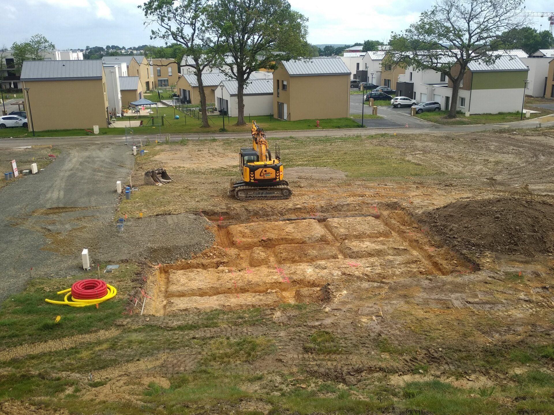 Chantier avec une pelleteuse creusant une tranchée de fondation dans un quartier résidentiel verdoyant