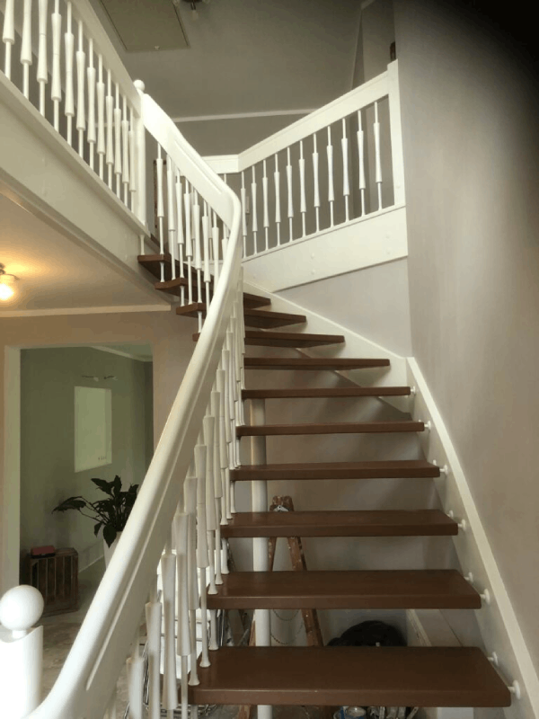 Eine Treppe mit Holzstufen und einem weißen Geländer